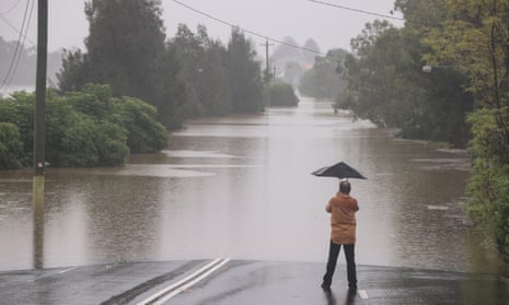 A man looks on at floodwaters in the suburb of McGraths Hill in Sydney, 23 March 2021.