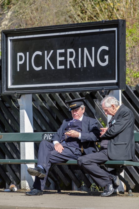Volunteer railway staff waiting for the next train, North York Moors Railway, Pickering, Yorkshire.