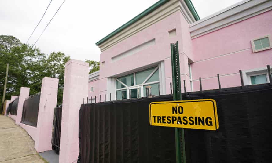 The fence around the Pink House is shrouded with a black tarp so that its clients may enter in privacy.