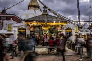 A woman stops to pray among other worshippers circumambulating the stupa at Boudhanath in Kathmandu, Nepal