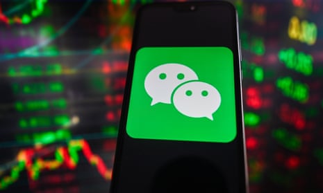 WeChat logo on a smartphone with stock market percentages in the background
