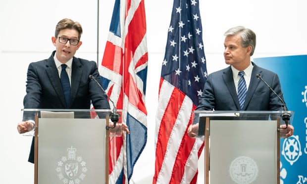 two men at podiums in front of UK and US flags