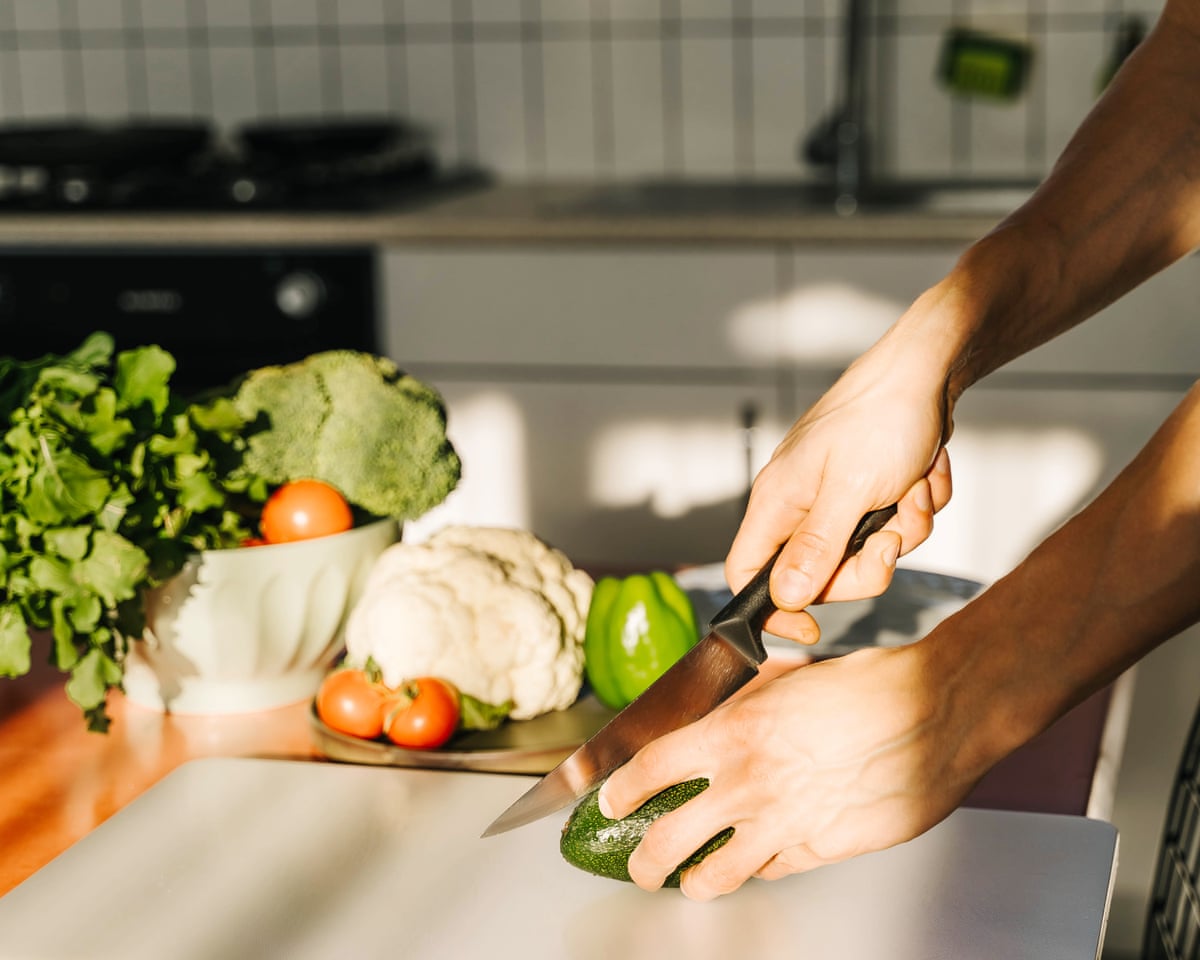 Young man cooking guacamole in kitchen