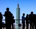 people stand at a lookout point with a building in the background
