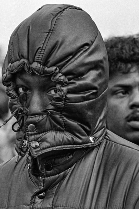 Man with the hood of his jacket tied tightly round his faces, only his eyes visible
