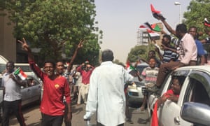 Sudanese protesters flash the victory sign as they march towards the military headquarters.