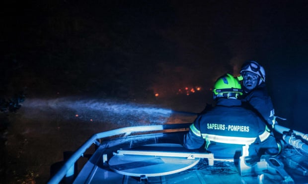 Les pompiers travaillent pendant la nuit sur le site de l'incendie.