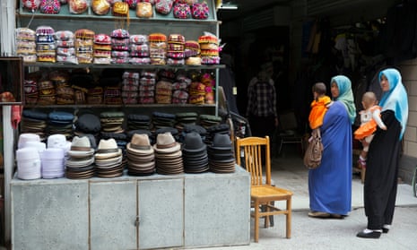 Uighur women in loose, full-length garments and headscarves associated with conservative Islam visit a market in the city of Aksu in western China’s Xinjiang province. 
