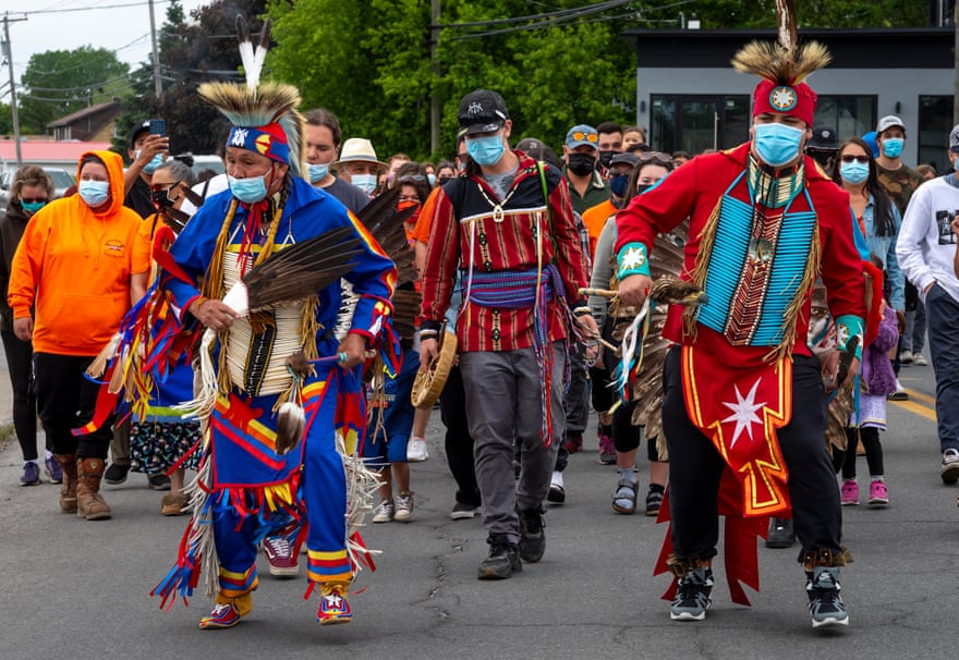 Members of the community of the Kahnawake Mohawk Territory, Quebec, march through the town on 30 May to commemorate the news that a mass grave of 215 Indigenous children was found at the Kamloops residential school.