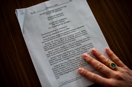 A hand holds a printed stack of papers