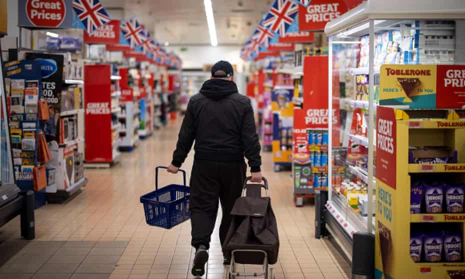 A customer shops for groceries in a branch of Sainsbury's