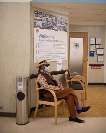 The bluesman at a local Walgreens waits to get a Covid vaccine. His outfit – a pointed hat, shades, and a sharp brown waistcoat – is again at odds with the sterile surroundings.