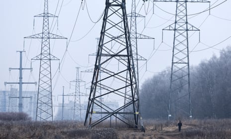 A man walks near electricity pylons