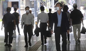 People wearing face masks to help protect against the spread of coronavirus walk through an underpass in Tokyo.