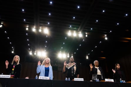 multiple people raise their hands at a hearing