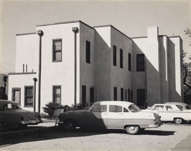 cars parked outside a modern looking apartment block