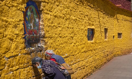 Members of the Tibetan Buddhist faithful pay their respects at a holy site