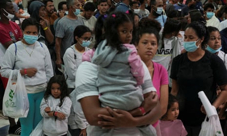 Asylum-seeking migrants wait in line before boarding buses to New York and Chicago at the Migrant Welcome Center managed by the city of El Paso, on 3 October.