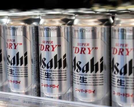 Rows of silver "Super Dry" Asahi beer cans displayed closely together on a supermarket shelf