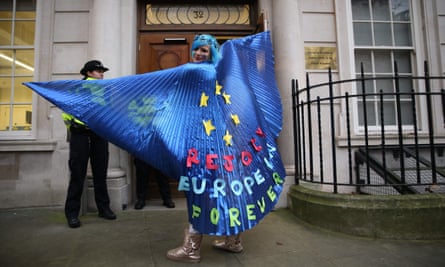 A pro-EU activist wearing a cape decorated with an EU flag design joins a rally organised by civil rights group New Europeans outside Europe House.