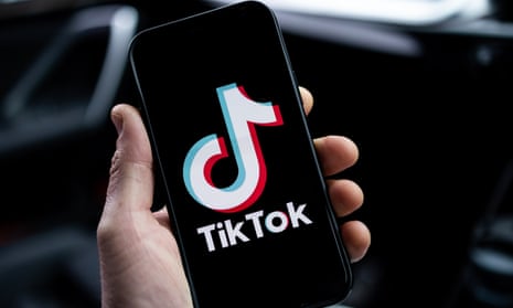 The TikTok logo is displayed on an iPhone