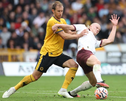 Craig Dawson and Erling Haaland fight for the ball during a Premier League match between Wolves and Manchester City