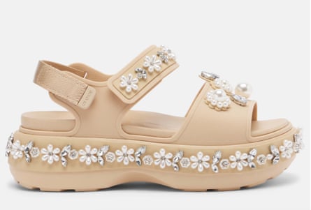 A side-on view of a beige strappy sandal with chunky platform sole decorated with pearl and crystal flower embellishments