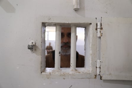 Muhammad Saqib Raza peers through the bars of a window in a cell door