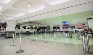 A lone passenger passes empty check-in counters at Sydney international airport