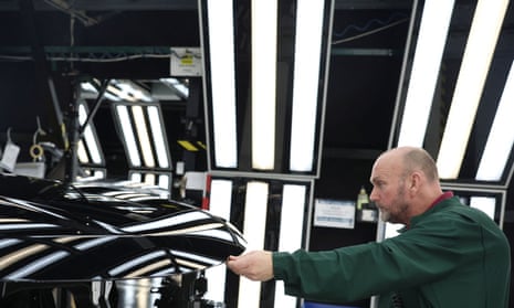 A member of staff checks the paintwork on a Range Rover