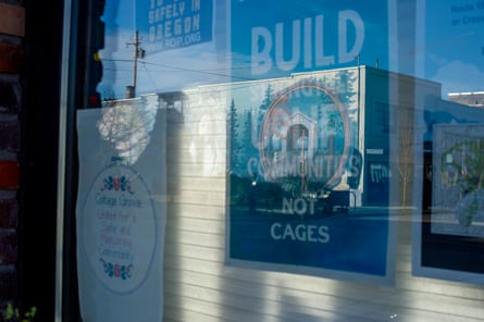 Posters in a store front window reflecting a city street