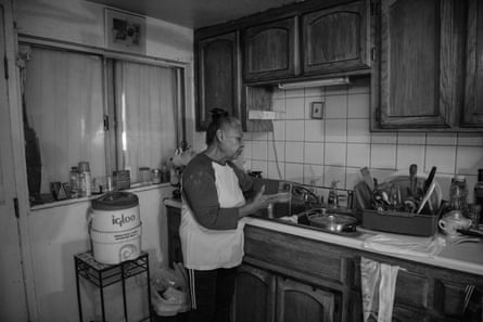 A woman turning on the kitchen sink