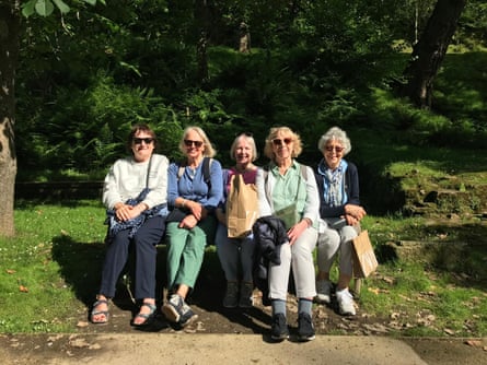 Group of older women on holiday smiling and sitting in park