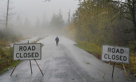 Clyde Shew, of Snoqualmie, Wash., checks out a section of W. Snoqualmie River Rd. NE that was closed due to high water conditions from the Snoqualmie River, Friday, Nov. 12, 2021, near Carnation, Wash. Flood watches and warnings were in place across the Northwest and forecasters said storms caused by an atmospheric river, known as the Pineapple Express and rain were expected to remain heavy in Oregon and Washington through Friday night. (AP Photo/Ted S. Warren)