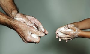 Man and young child washing hands with soap