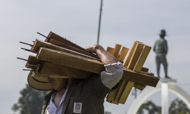A city employee removes wooden crosses that were placed in a plaza by organizations protesting against the government inaction over the alarming murder rate in San Salvador, El Salvador.