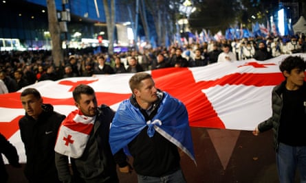 Georgian Dream supporters holding a large flag