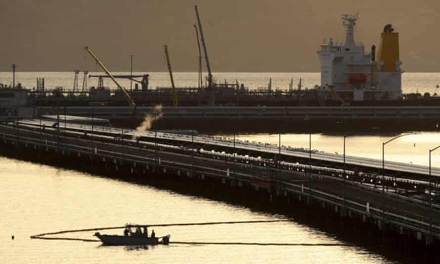 An absorbent boom is placed next to the Chevron Richmond Long Wharf to contain an oil spill at the Chevron Refinery that sent gallons of oil into San Francisco Bay at Point Richmond in Richmond, California