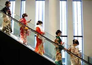 Women wearing kimono and protective masks ride on an escalator at Coming of Age Day celebration ceremony venue, amid the coronavirus disease (COVID-19) outbreak, in Tokyo, Japan