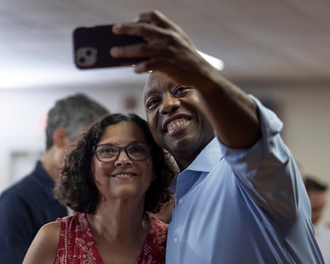 Senator Tim Scott, Republican candidate for US president, takes a selfie with a supporter.