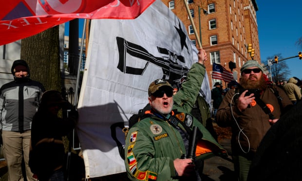 A pro-gun protester, holding an automatic rifle, waves a flag outside the Virginia State Capitol in Richmond, in January.