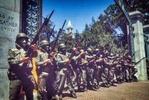 National guardsmen wearing gas masks face protesters before a helicopter disperses tear gas over the UC Berkeley campus.