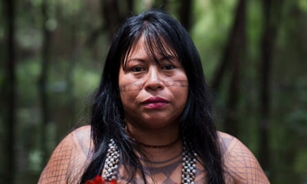 An Indigenous woman with facial and body tattoos in the forest