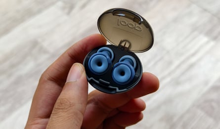 A person holding a case of blue loop earplugs