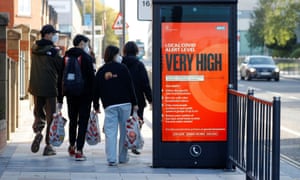 The spread of the coronavirus disease (COVID-19), in Liverpool<br>People wearing protective masks walk past a covid warning sign as the spread of the coronavirus disease (COVID-19) continues, in Liverpool, Britain October 15, 2020. REUTERS/Phil Noble