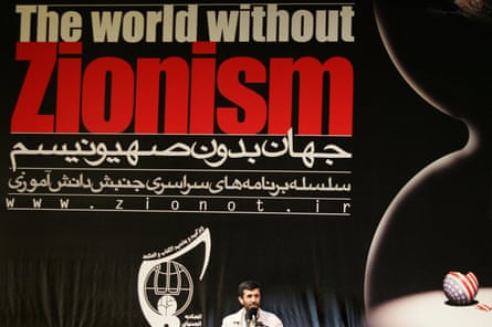 Mahmoud Ahmadinejad gives a speech in front of a banner calling for a world without Zionism