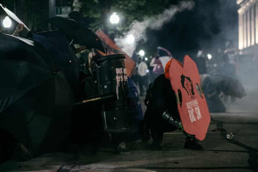 Protesters use homemade shields and umbrellas to repel munitions deployed by police in Kenosha, Wisconsin on August 25, 2020.