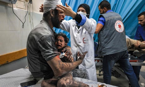 PALESTINIAN-ISRAEL-CONFLICTEDITORS NOTE: Graphic content / A man holds a child, survivors of Israeli bombardment, as they are treated at a trauma ward at Nasser hospital in Khan Yunis in the southern Gaza Strip on October 24, 2023 amid the ongoing battles between Israel and the Palestinian group Hamas. Thousands of civilians, both Palestinians and Israelis, have died since October 7, 2023, after Palestinian Hamas militants based in the Gaza Strip entered southern Israel in an unprecedented attack triggering a war declared by Israel on Hamas with retaliatory bombings on Gaza. (Photo by Mahmud HAMS / AFP) (Photo by MAHMUD HAMS/AFP via Getty Images)
