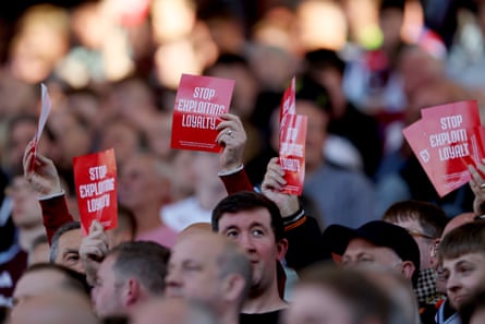 Aston Villa fans hold up Stop Exploiting Loyalty signs.