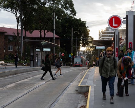 People cross the tram lines at Surry Hills tram stop the day after a person was killed while crossing the tracks.